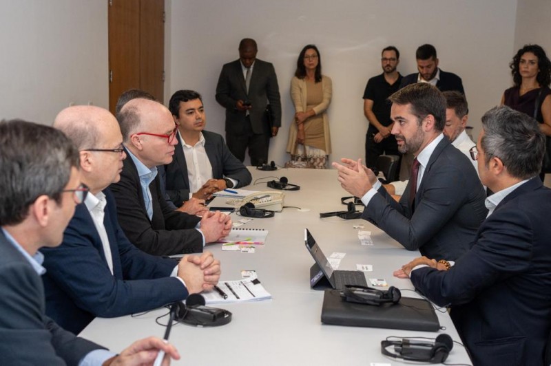 Homens conversam em torno de uma mesa de trabalho, liderados pelo governador Eduardo Leite